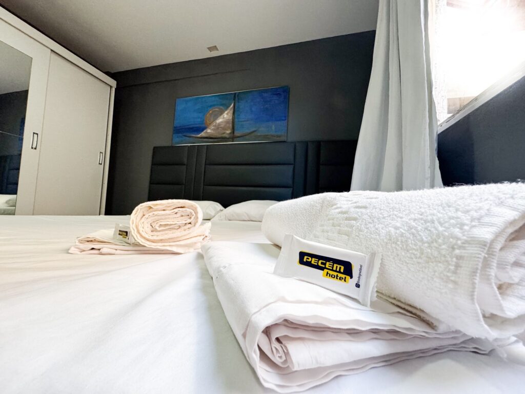 Enxoval com etiqueta do Pecém Hotel sobre a cama da suíte